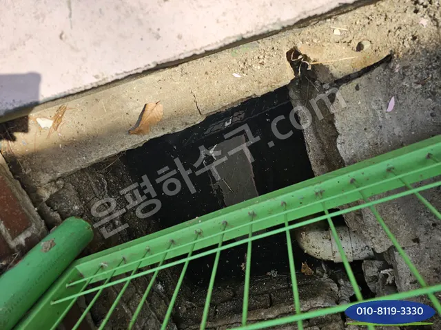 난간 아래 배수로 맨홀을 열어 둔 모습