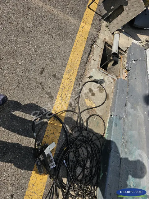 도로변 빗물받이에 케이블을 넣는 작업